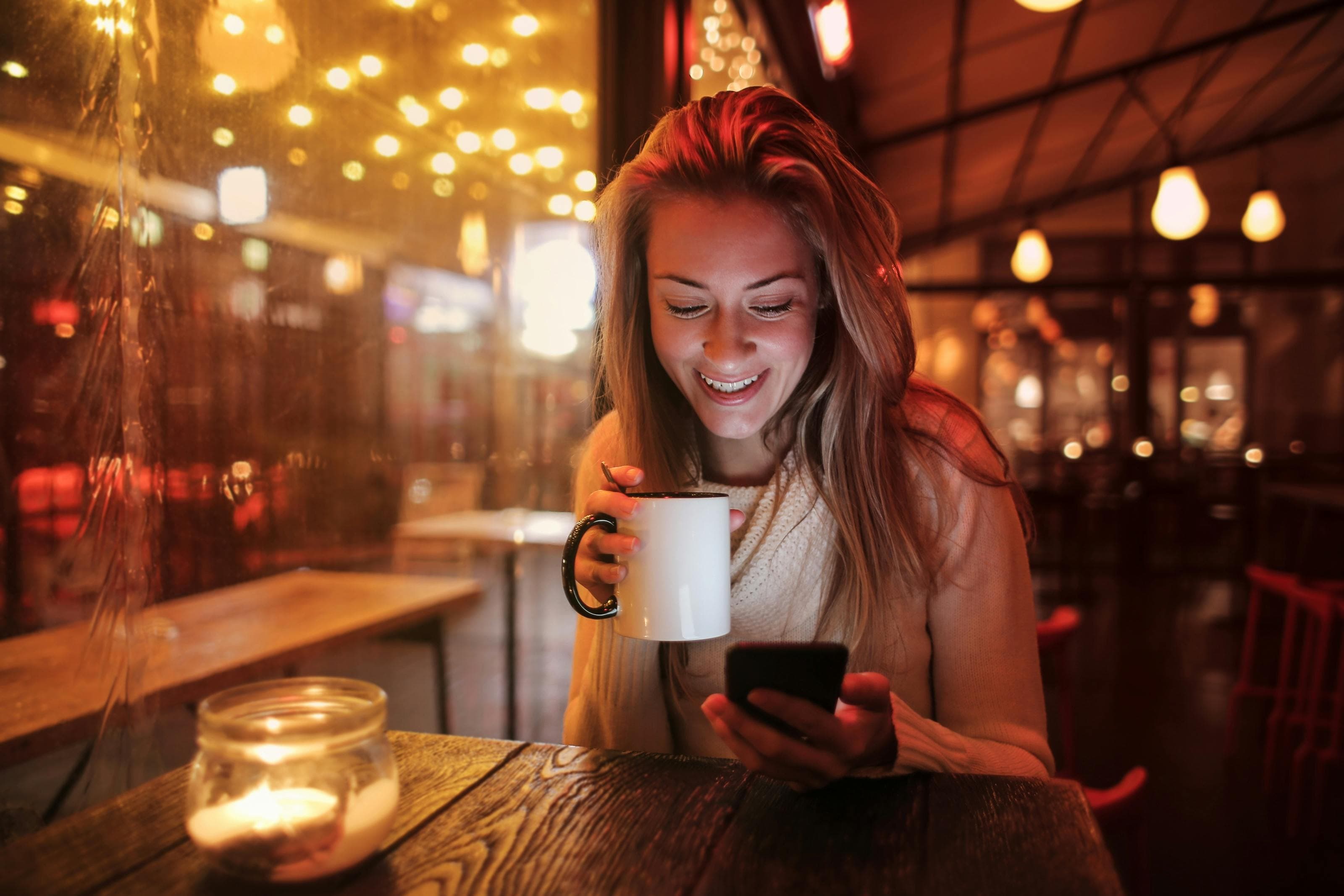 Woman holding phone and coffee